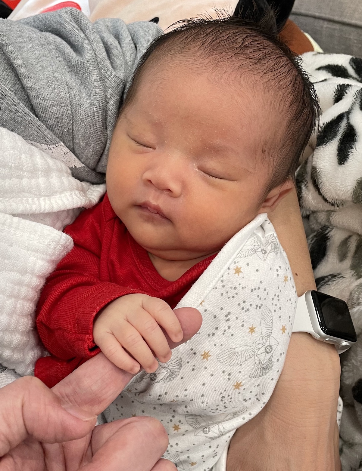 Rhea holding grandpa's finger